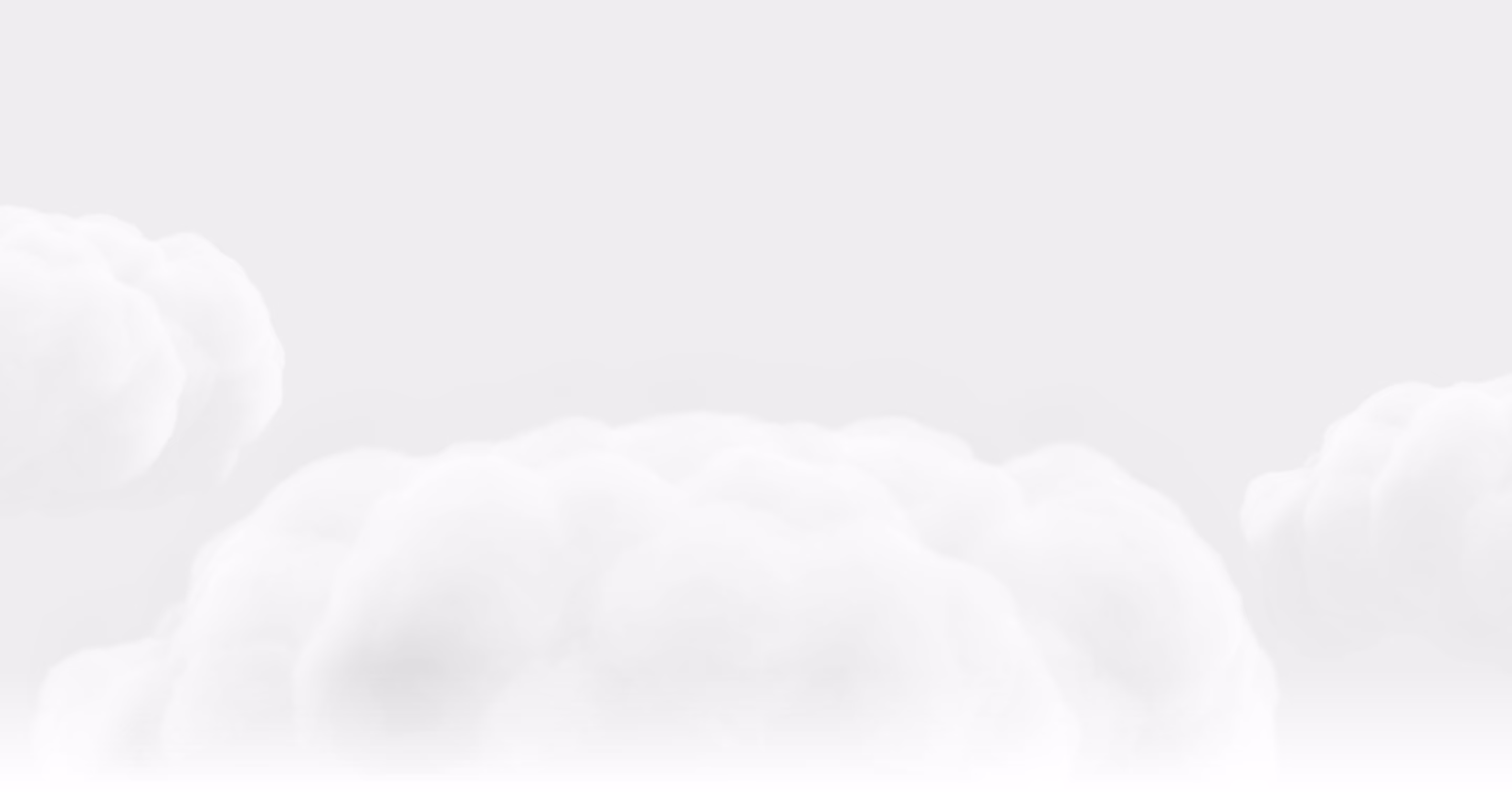 Soft, fluffy white clouds against a pale gray sky background.